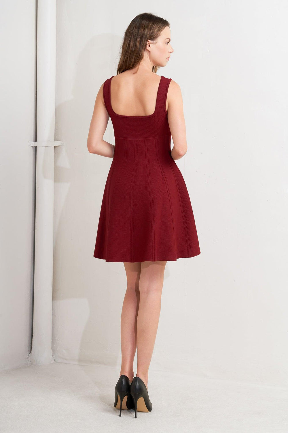 A solid sweater knit mini dress featuring square neckline, sleeveless and full skirt