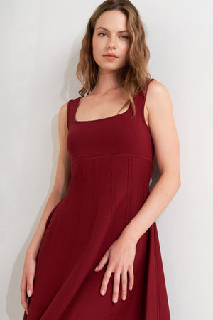 A solid sweater knit mini dress featuring square neckline, sleeveless and full skirt