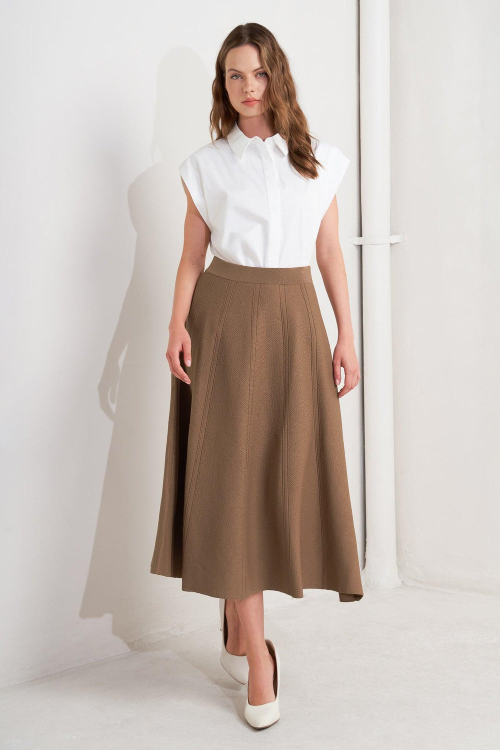 Person wearing a brown skirt and white shoes on a white background - Flying Tomato