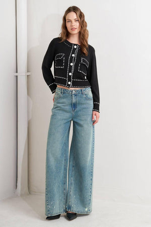 A sweater knit top featuring round neckline, button down, long sleeve and stitch edge detail
