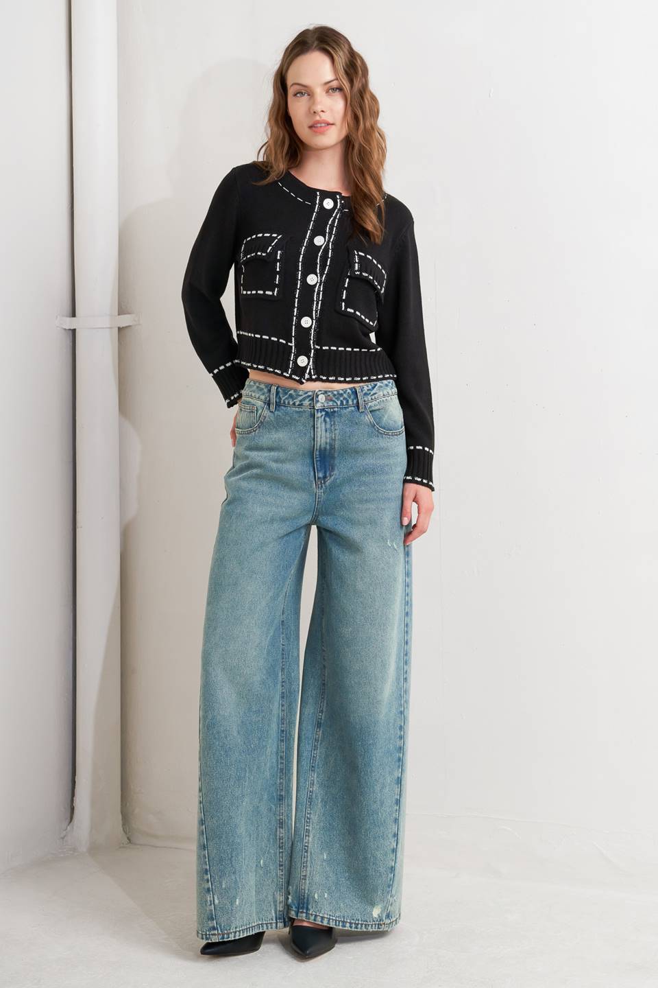 A sweater knit top featuring round neckline, button down, long sleeve and stitch edge detail