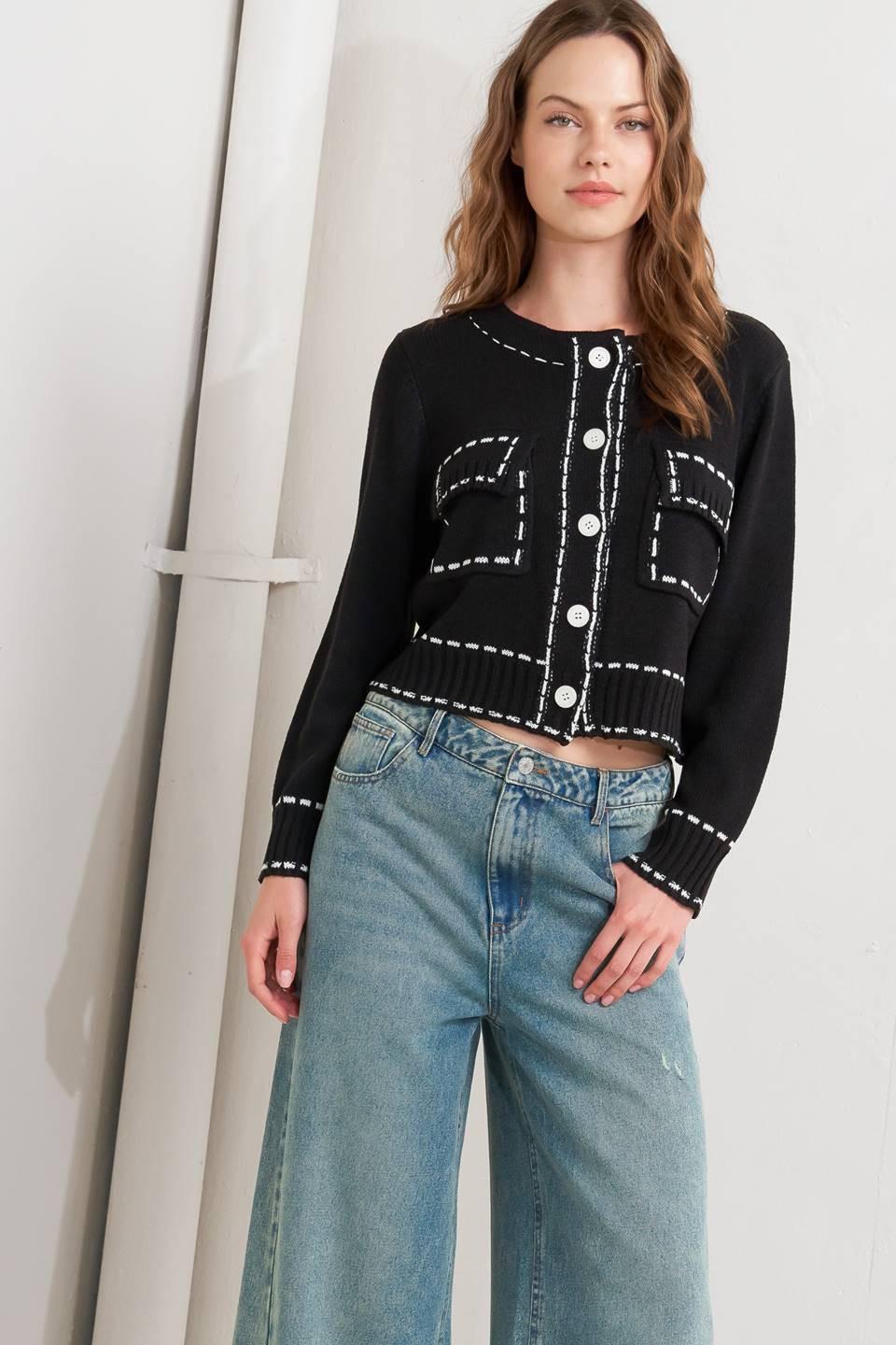 A sweater knit top featuring round neckline, button down, long sleeve and stitch edge detail