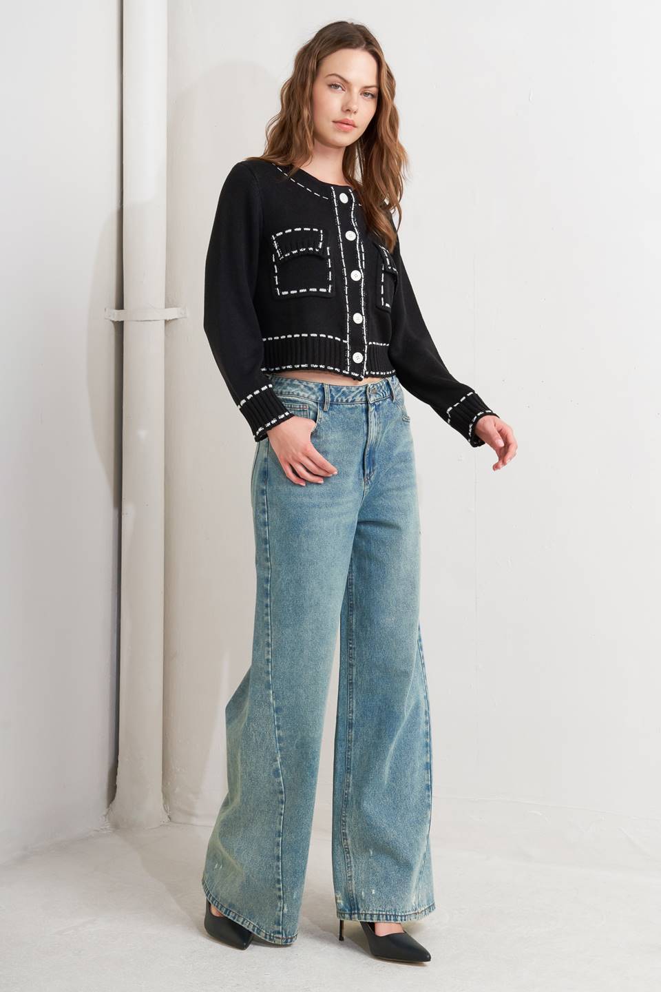 A sweater knit top featuring round neckline, button down, long sleeve and stitch edge detail