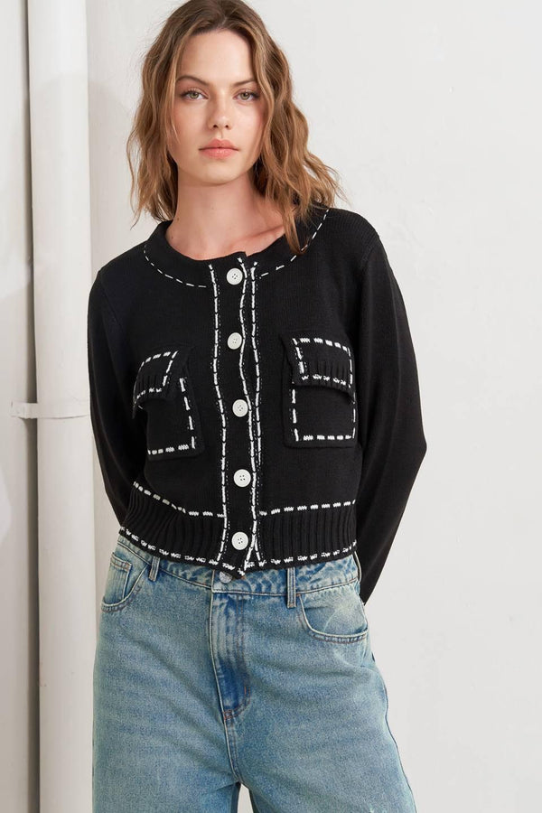 A sweater knit top featuring round neckline, button down, long sleeve and stitch edge detail