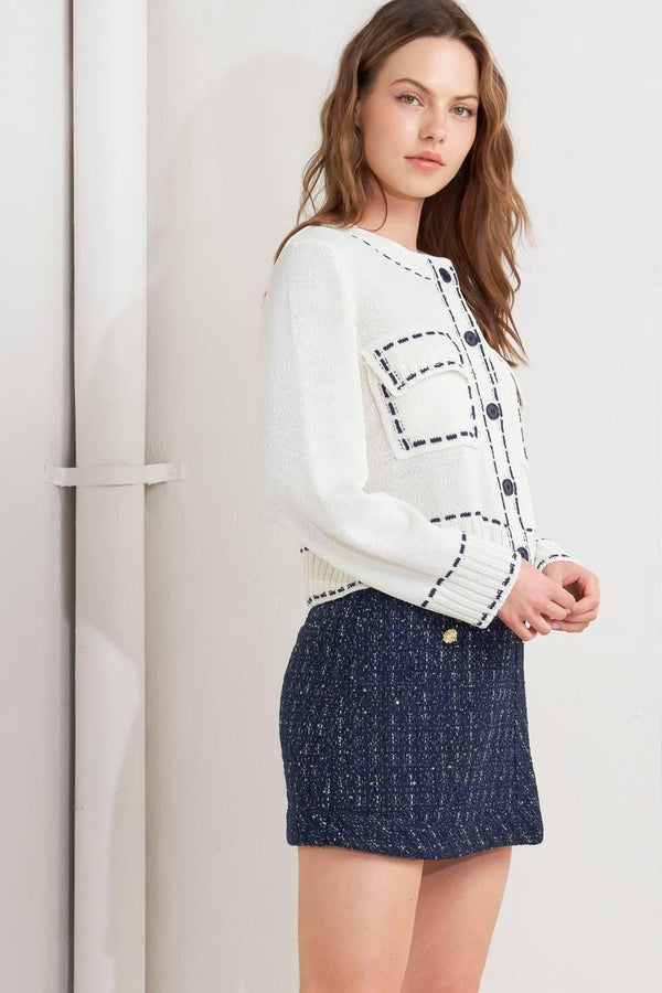 A sweater knit top featuring round neckline, button down, long sleeve and stitch edge detail