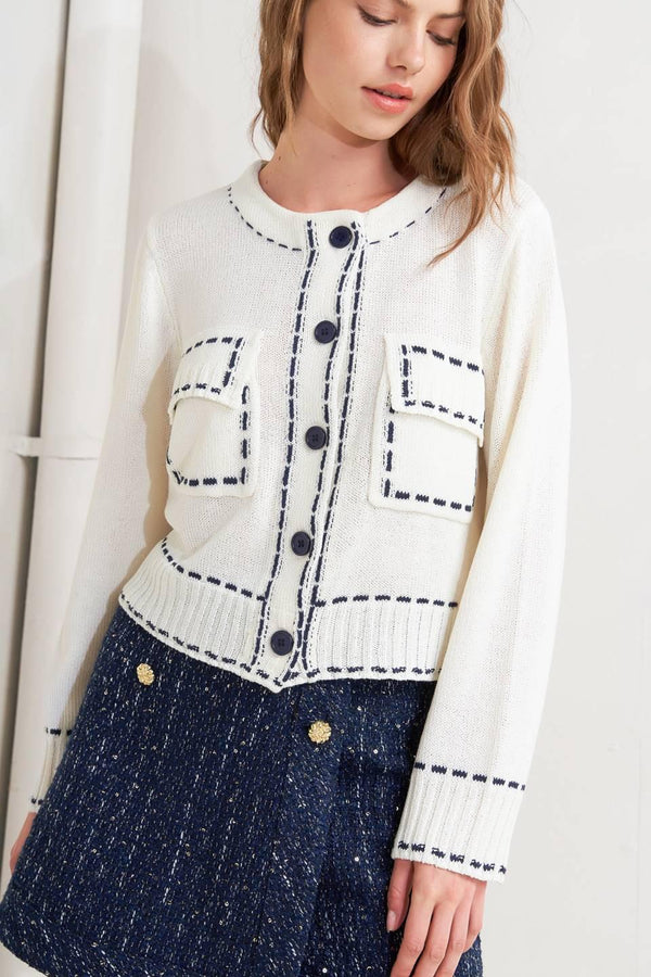 A sweater knit top featuring round neckline, button down, long sleeve and stitch edge detail