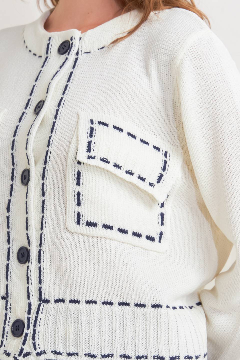 A sweater knit top featuring round neckline, button down, long sleeve and stitch edge detail