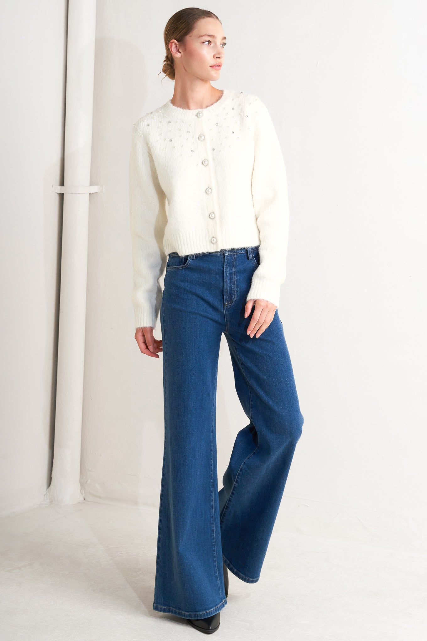 A sweater knit cardigan featuring round neckline, long sleeve and jewel embellishment and button