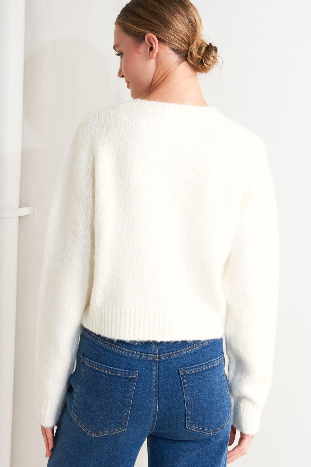 A sweater knit cardigan featuring round neckline, long sleeve and jewel embellishment and button