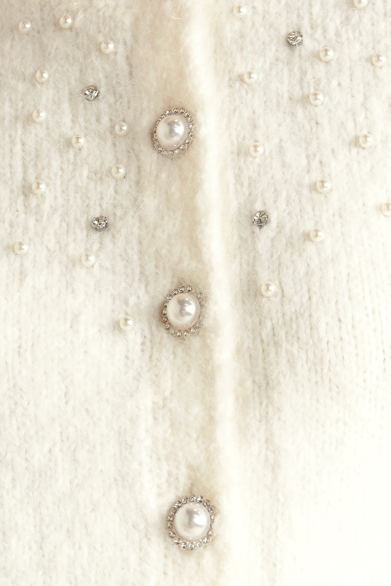 A sweater knit cardigan featuring round neckline, long sleeve and jewel embellishment and button