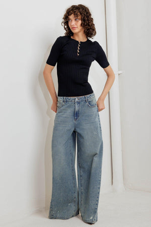 A ribbed sweater knit top featuring round neckline, front button closure and short sleeve