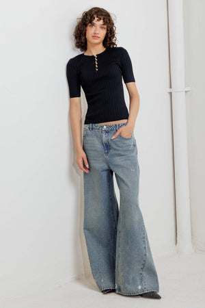 A ribbed sweater knit top featuring round neckline, front button closure and short sleeve