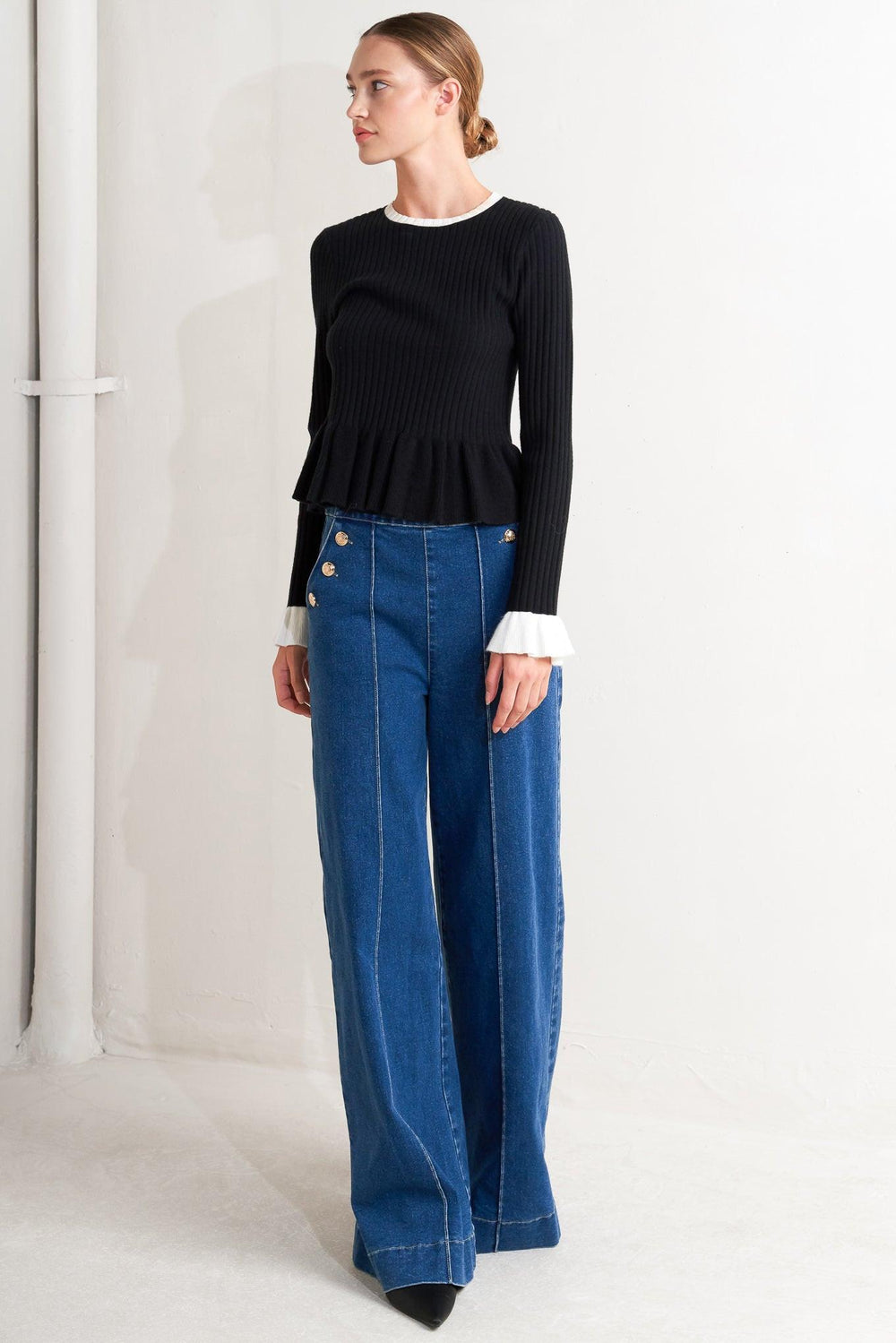 A sweater knit top featuring round neckline, long sleeve with ruffled sleeve and ruffled peplum