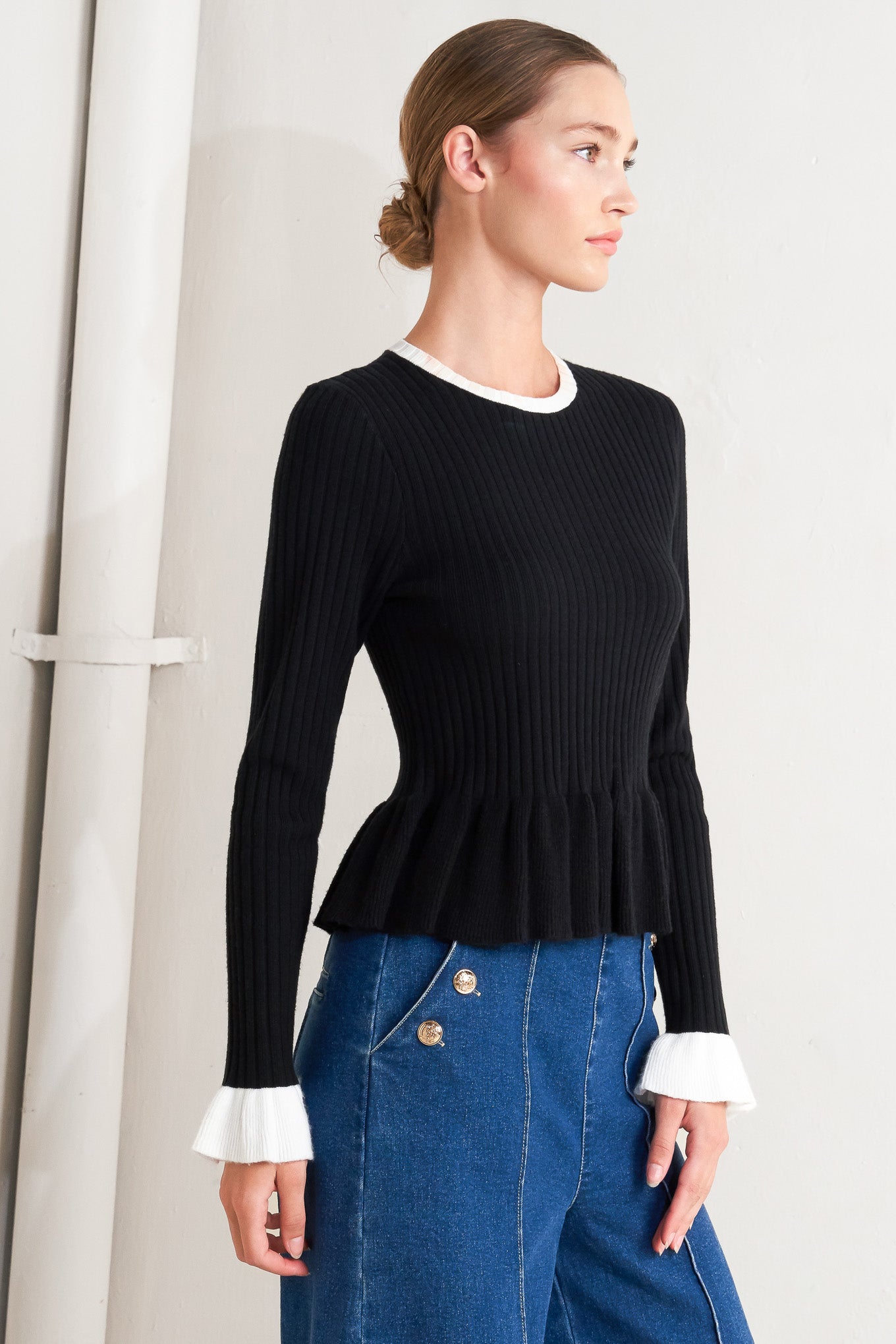A sweater knit top featuring round neckline, long sleeve with ruffled sleeve and ruffled peplum