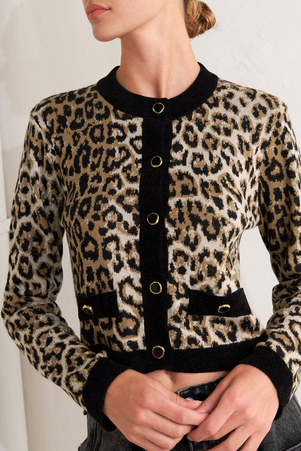 A sweater knit cardigan with round neckline, long sleeve and front button closure