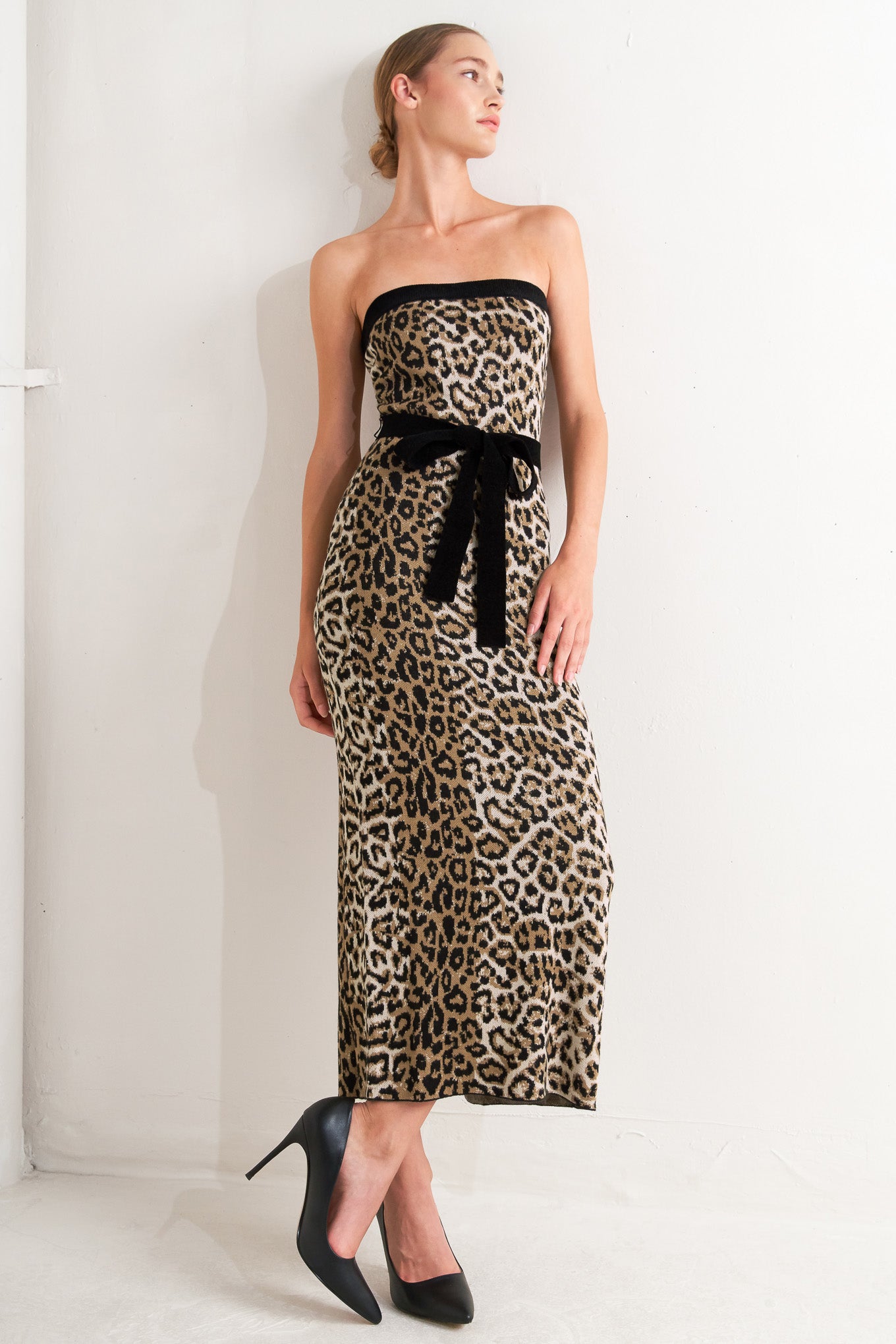 A sweater knit midi dress featuring strapless, contrasting belt and back slit