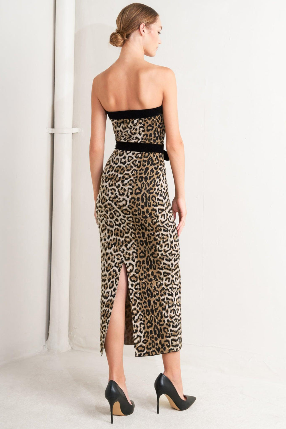 A sweater knit midi dress featuring strapless, contrasting belt and back slit