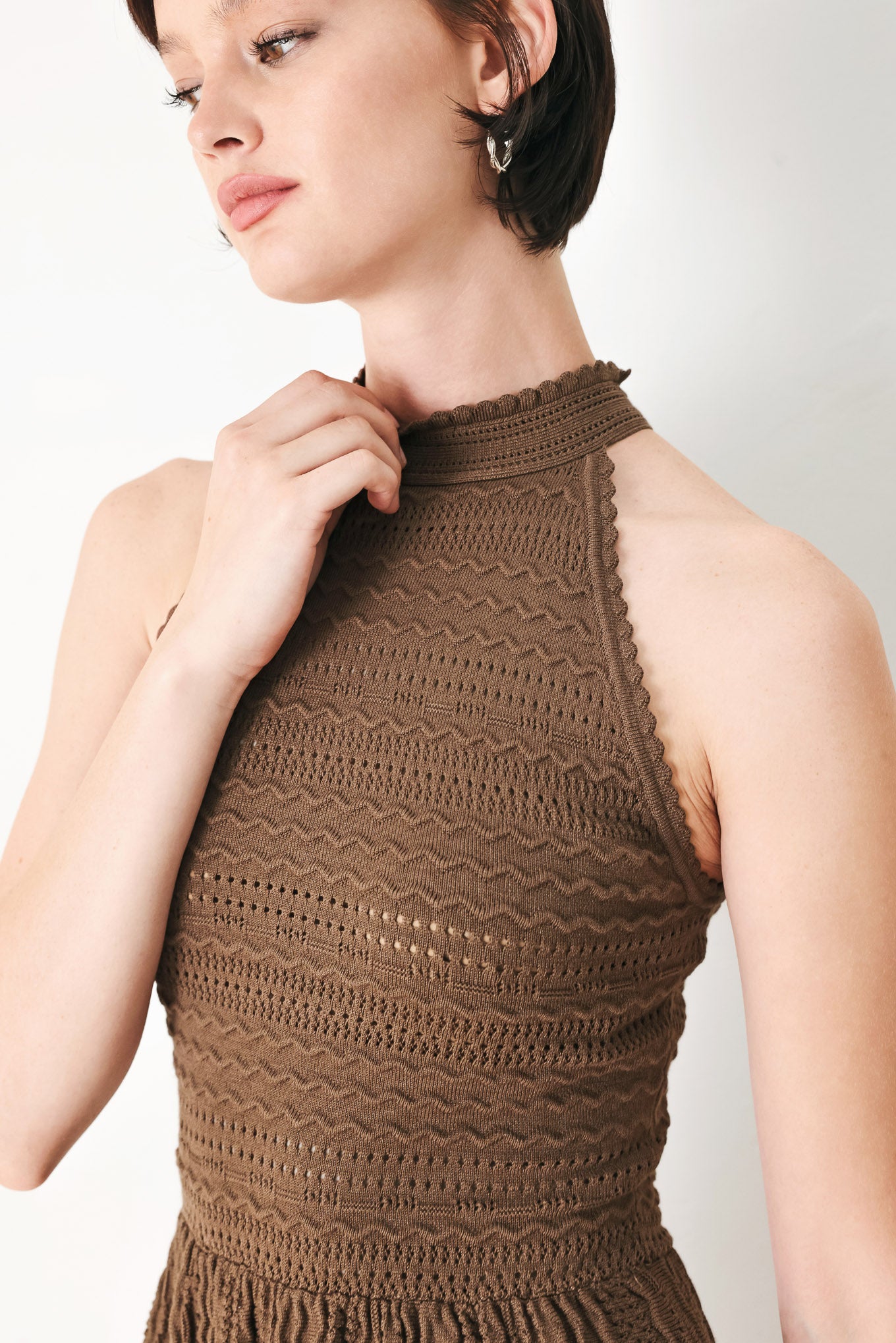 A sweater knit mini dress with halter neckline and back neck button closure