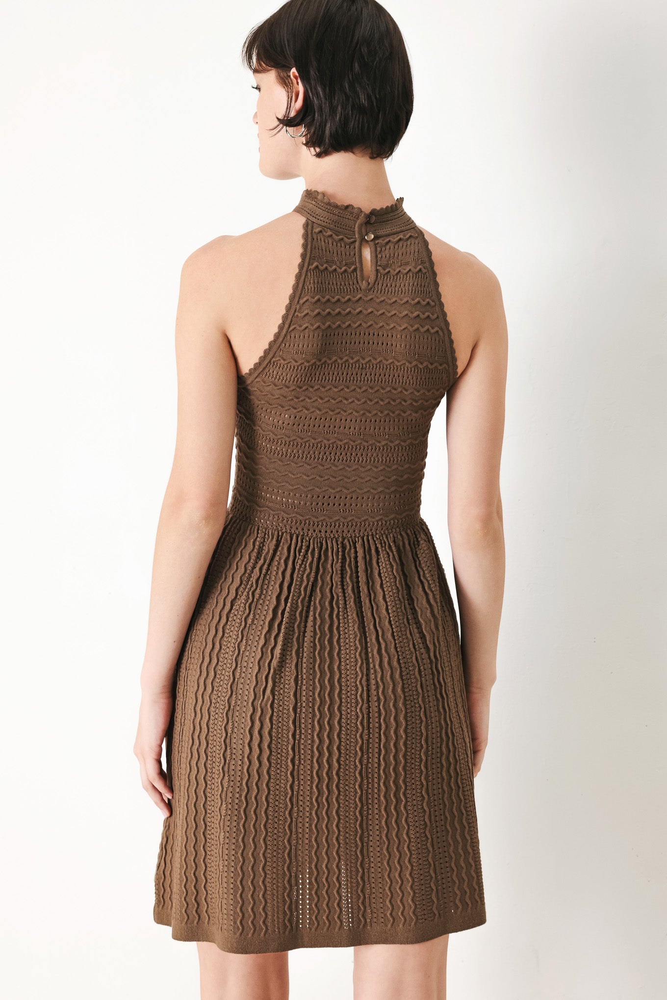 A sweater knit mini dress with halter neckline and back neck button closure