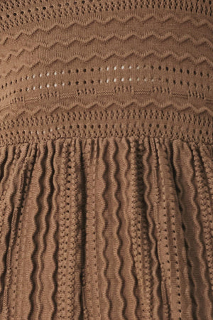 A sweater knit mini dress with halter neckline and back neck button closure