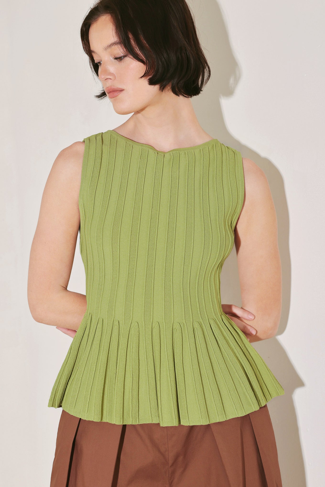 
A sweater knit top with wide neckline, sleeveless and peplum

Details:

Self : 52% Viscose 28% Nylon 20% Lycra

Size &amp; Fit

- Model is 5`8" And Wearing Size Small
- Measurements Taken From Size Small
- Approx. Length: 23"