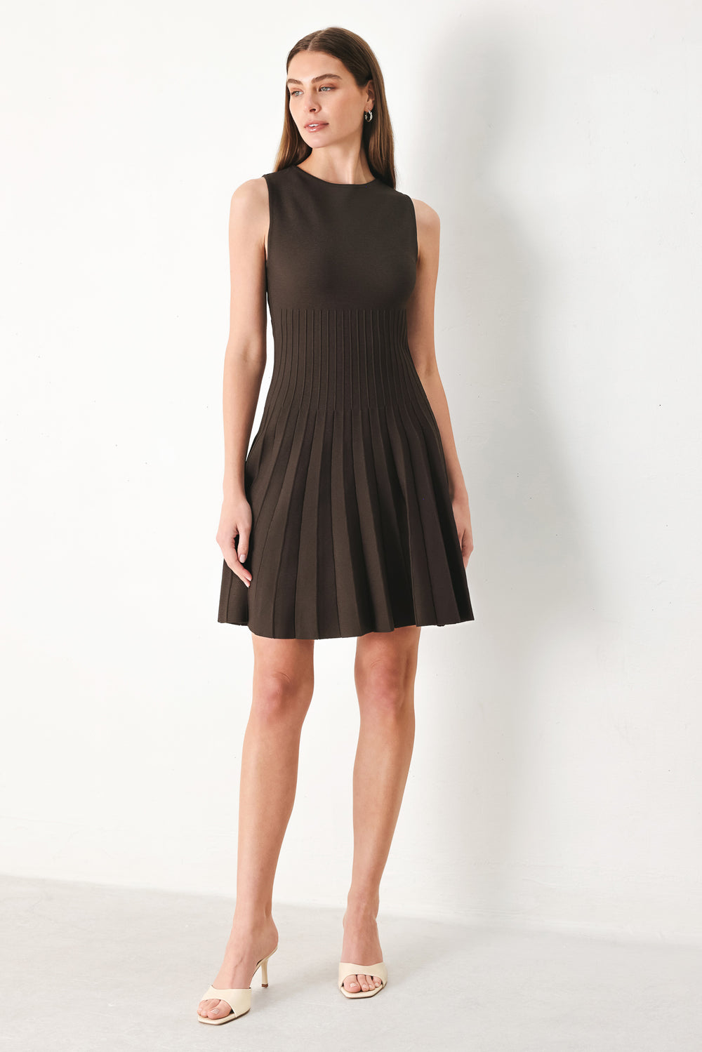 Woman wearing a brown sleeveless sweater knit mini dress with pleated skirt | FREEMARKET | Flying Tomato