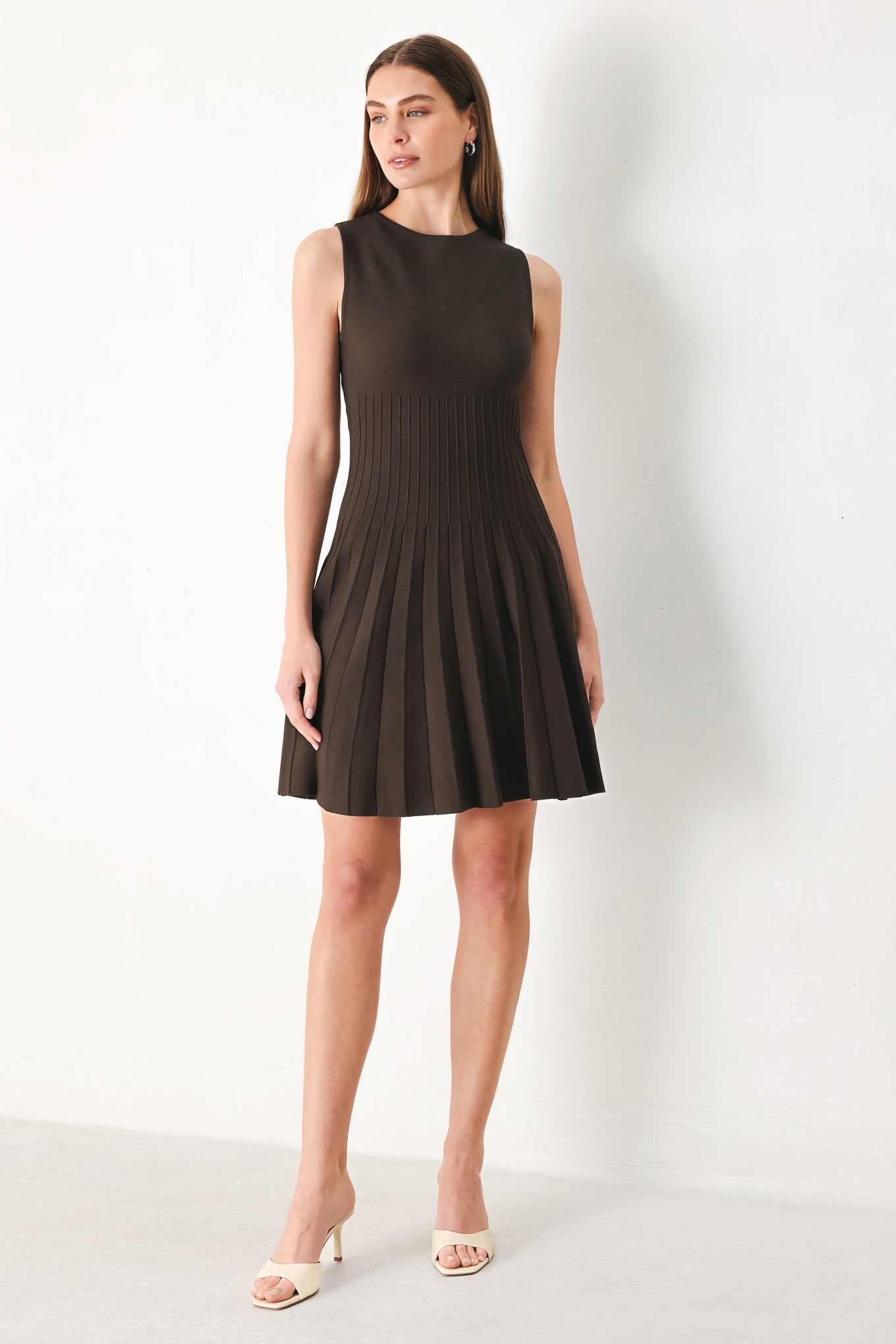 Woman wearing a brown sleeveless sweater knit mini dress with pleated skirt | FREEMARKET | Flying Tomato