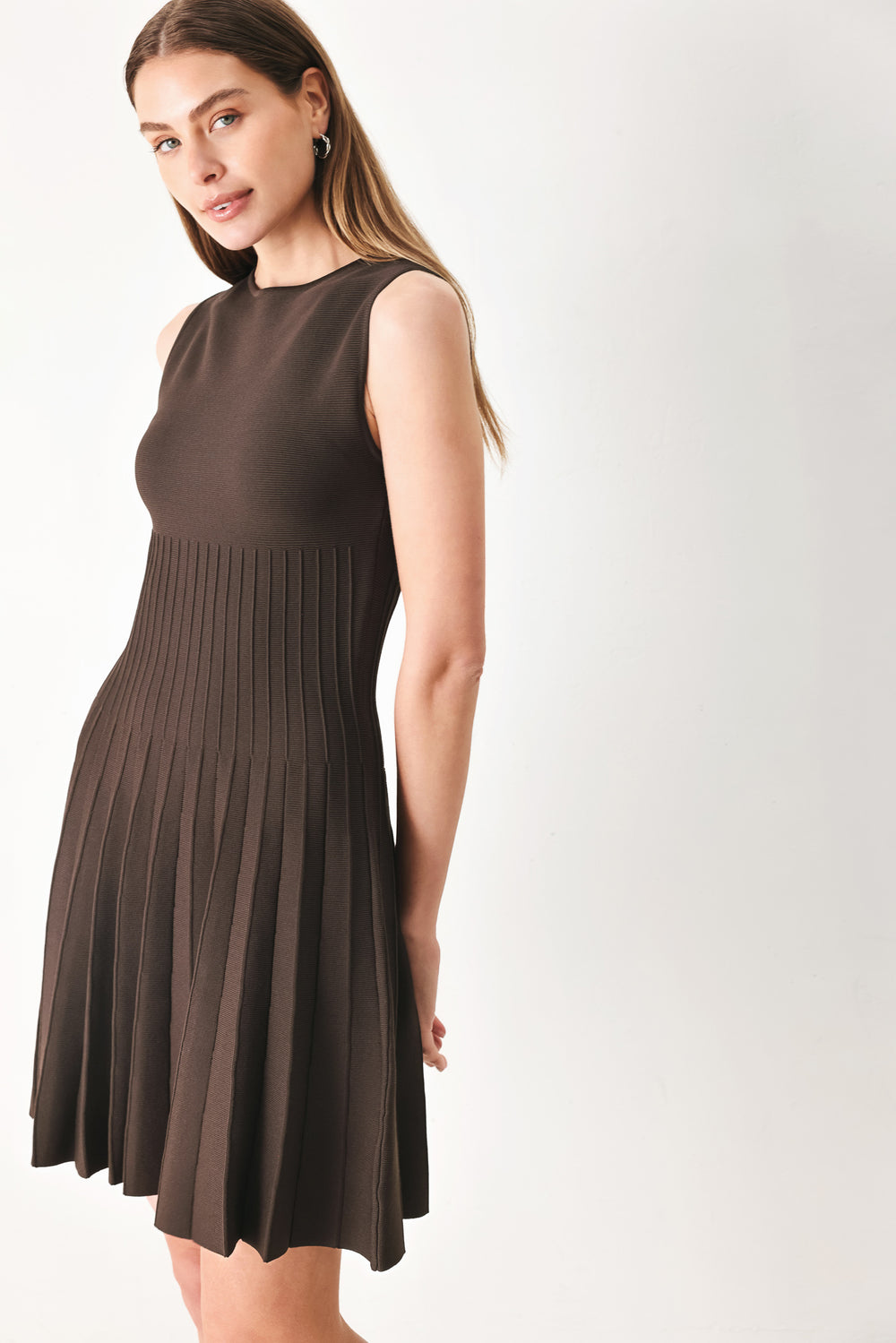 Woman wearing a brown sleeveless sweater knit mini dress with pleated skirt | FREEMARKET | Flying Tomato