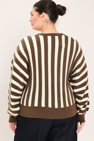 A woman wearing a brown and cream vertical striped knit sweater with long balloon sleeves and ribbed cuffs, paired with dark jeans | Plus Curve Flying Tomato