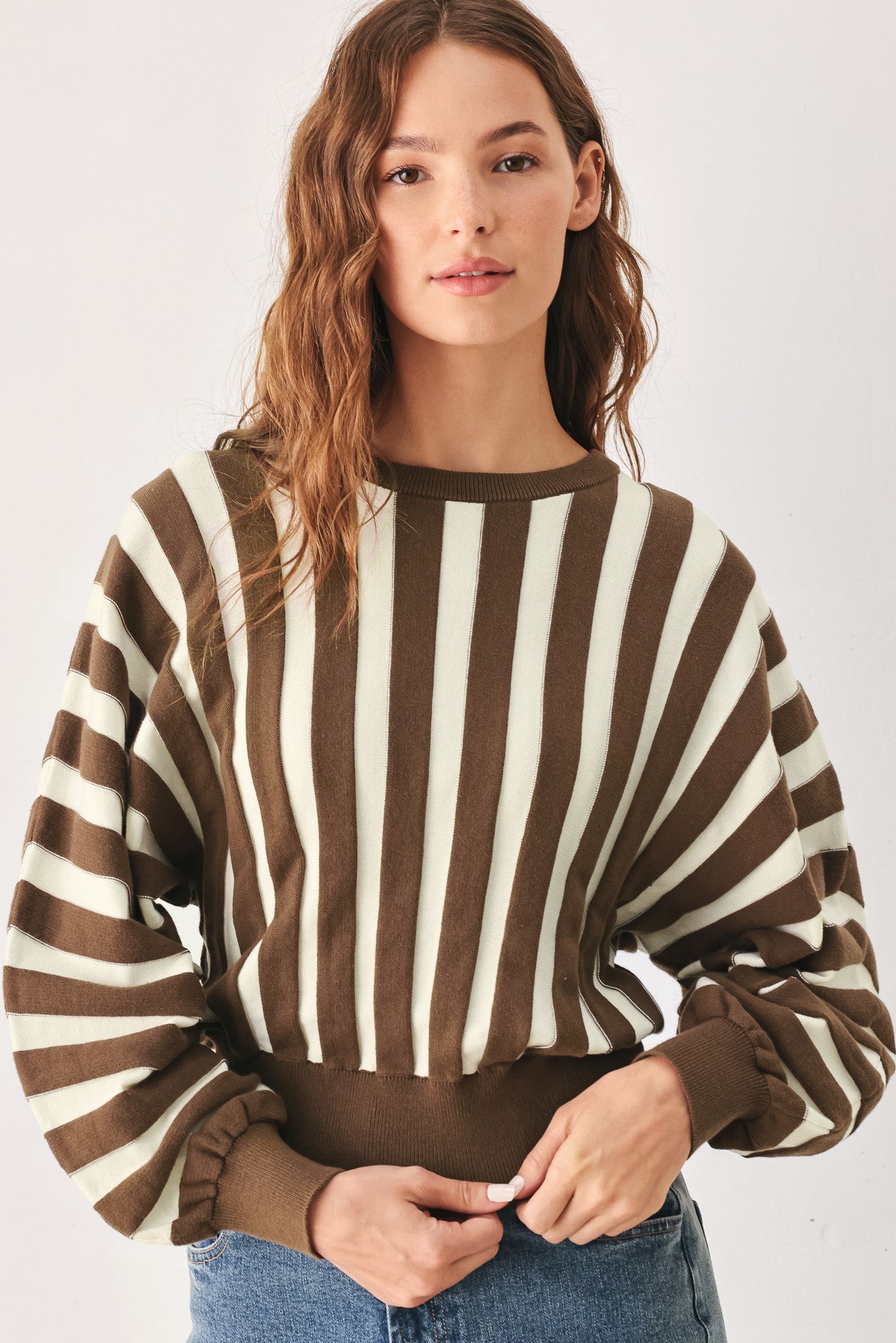 A woman wearing a brown and ivory striped long-sleeve knit top | FREEMARKET