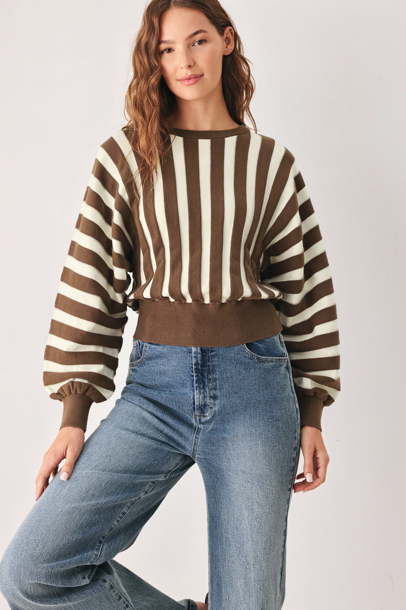 A woman wearing a brown and ivory striped long-sleeve knit top | FREEMARKET