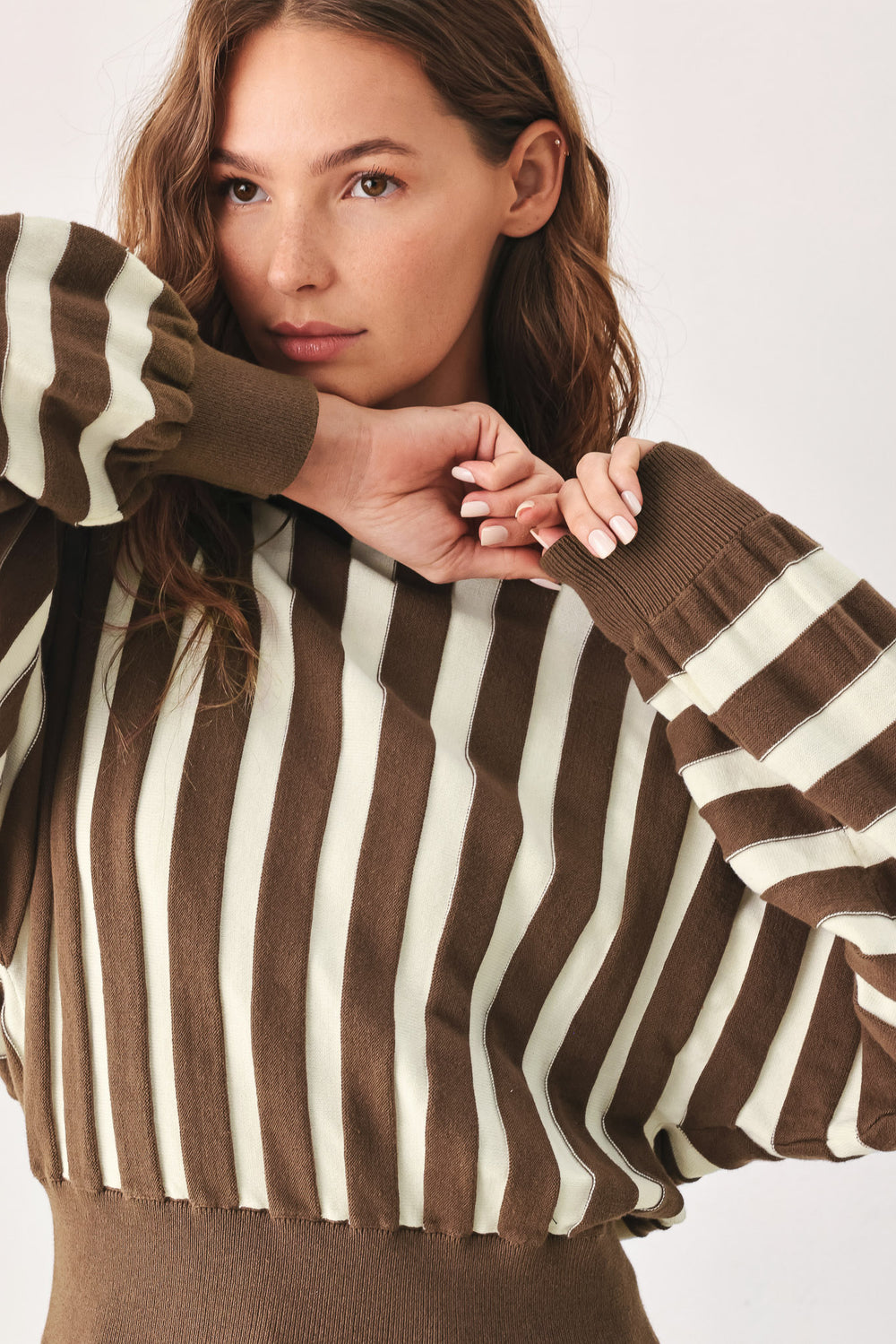 A woman wearing a brown and ivory striped long-sleeve knit top | FREEMARKET