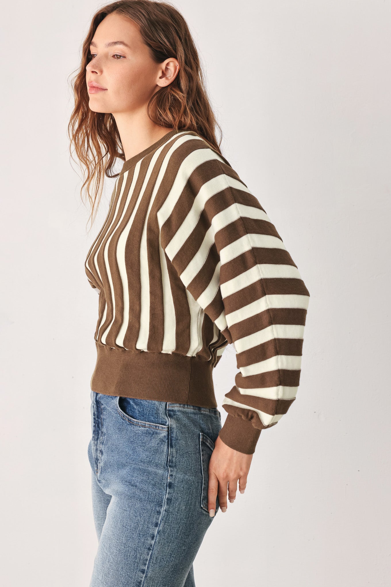 A woman wearing a brown and ivory striped long-sleeve knit top | FREEMARKET