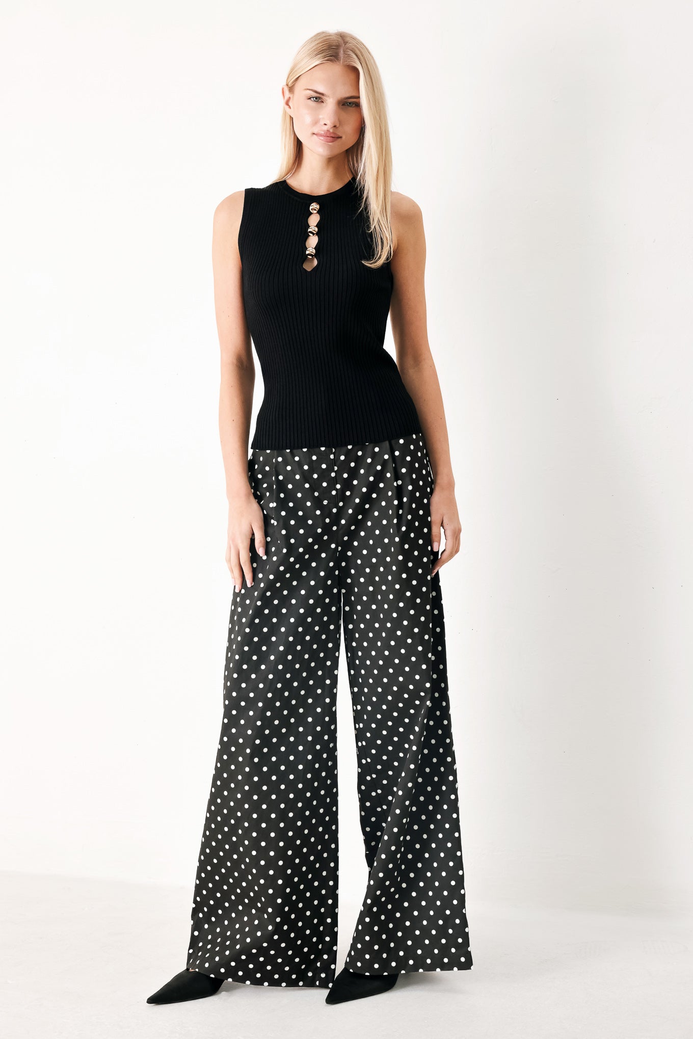 Woman wearing a black ribbed sleeveless top with a cutout design | FREEMARKET