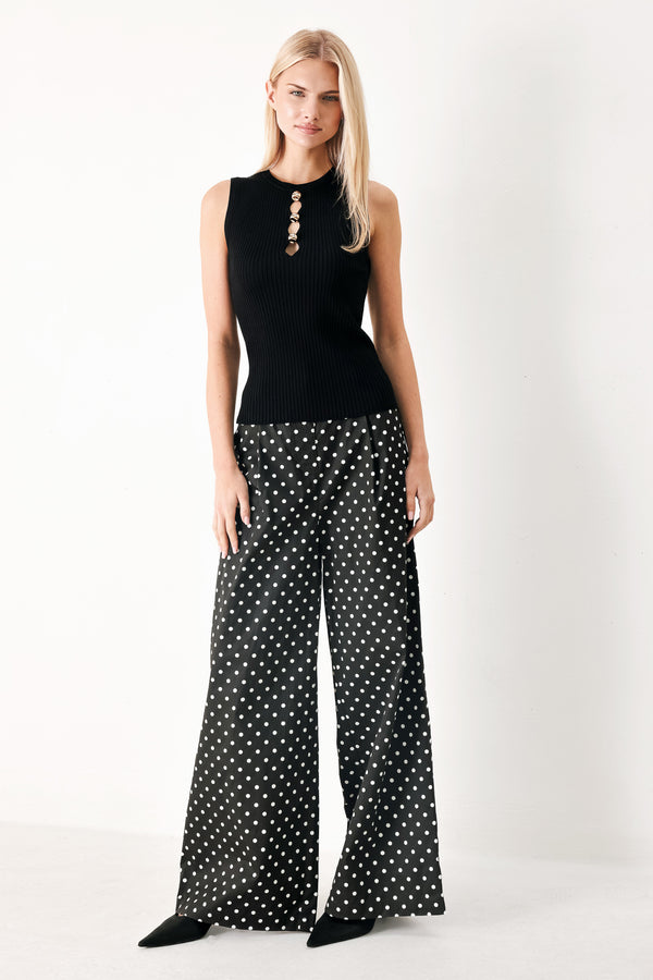 Woman wearing a black ribbed sleeveless top with a cutout design | FREEMARKET
