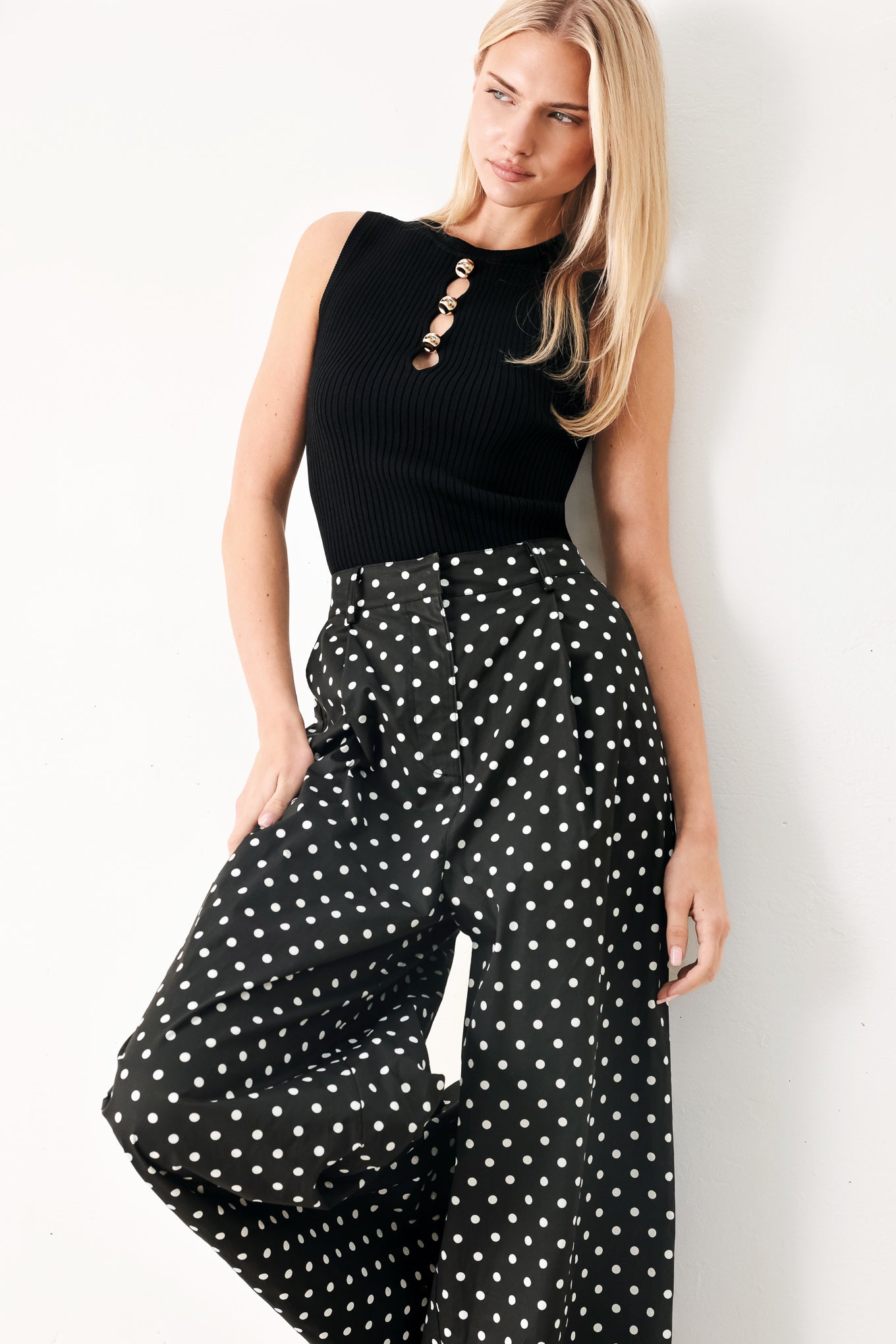 Woman wearing a black ribbed sleeveless top with a cutout design | FREEMARKET