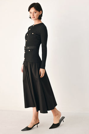A model wearing a black long-sleeve midi dress with gold-tone decorative buttons down the front, a matching black belt with gold studs, and a flared drop-waist skirt | FREEMARKET