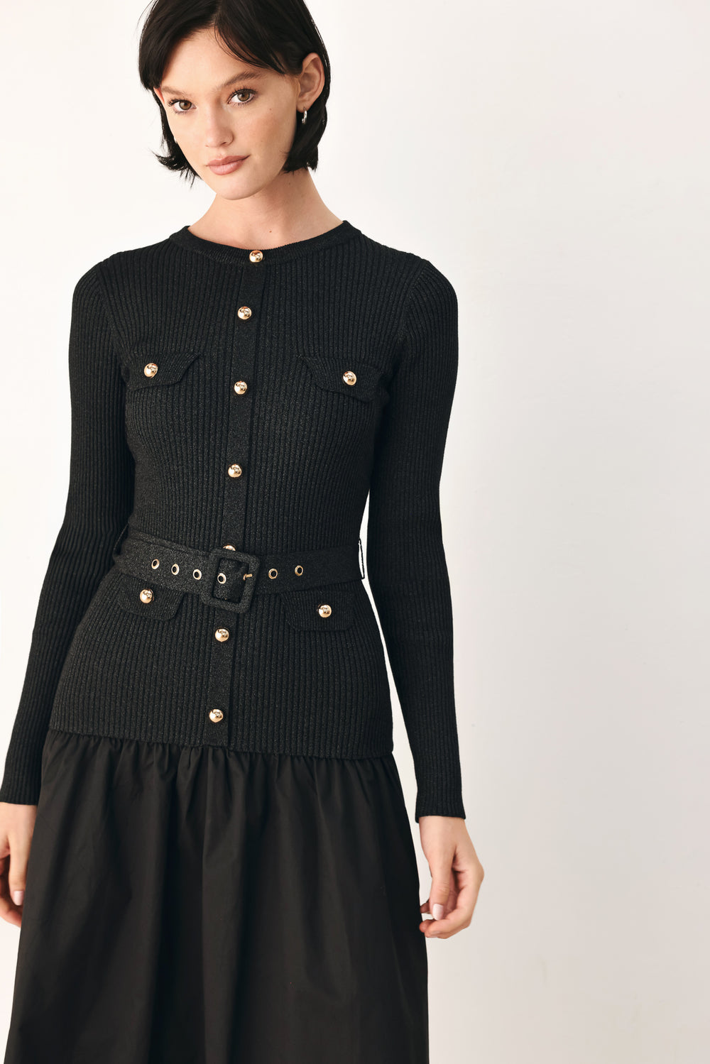 A model wearing a black long-sleeve midi dress with gold-tone decorative buttons down the front, a matching black belt with gold studs, and a flared drop-waist skirt | FREEMARKET