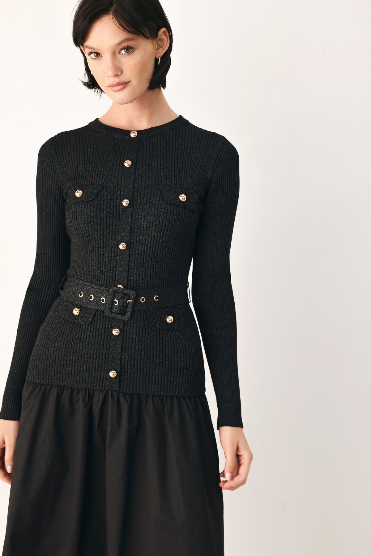 A model wearing a black long-sleeve midi dress with gold-tone decorative buttons down the front, a matching black belt with gold studs, and a flared drop-waist skirt | FREEMARKET