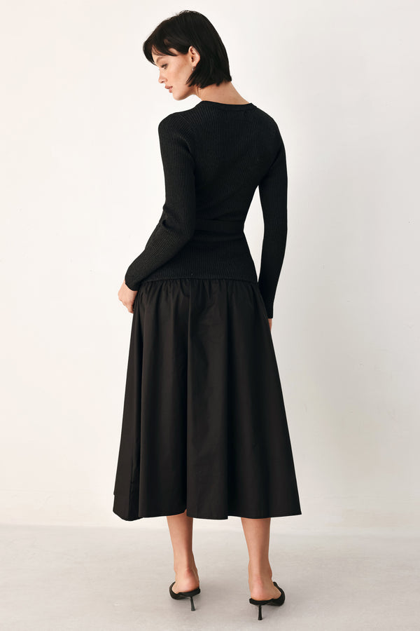 A model wearing a black long-sleeve midi dress with gold-tone decorative buttons down the front, a matching black belt with gold studs, and a flared drop-waist skirt | FREEMARKET