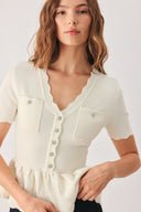 A woman wearing a short-sleeve off-white sweater knit blouse with a scalloped V-neckline, front buttons, and chest pockets | FREEMARKET