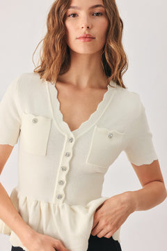 A woman wearing a short-sleeve off-white sweater knit blouse with a scalloped V-neckline, front buttons, and chest pockets | FREEMARKET