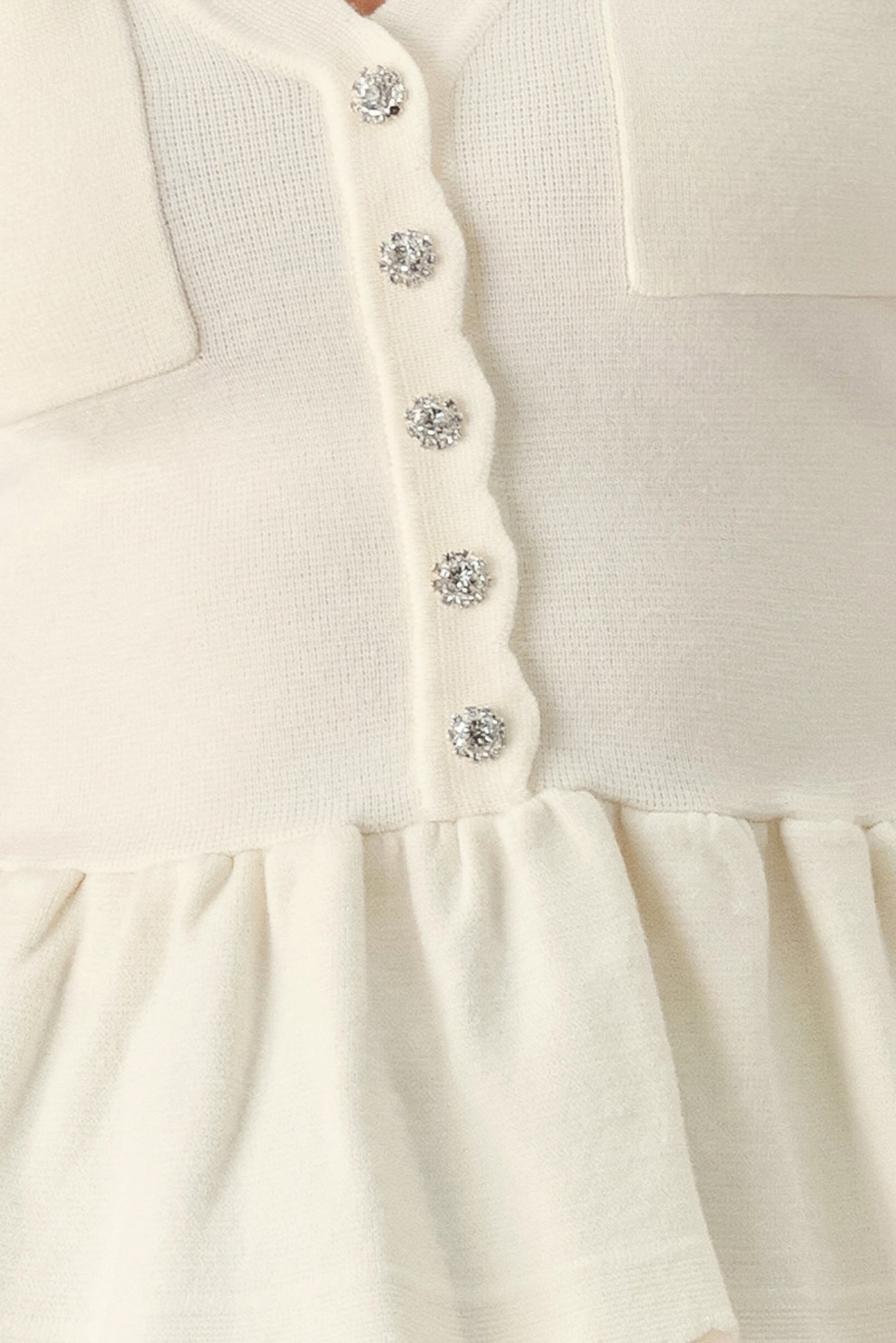 A woman wearing a short-sleeve off-white sweater knit blouse with a scalloped V-neckline, front buttons, and chest pockets | FREEMARKET