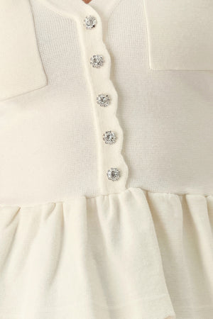 A woman wearing a short-sleeve off-white sweater knit blouse with a scalloped V-neckline, front buttons, and chest pockets | FREEMARKET