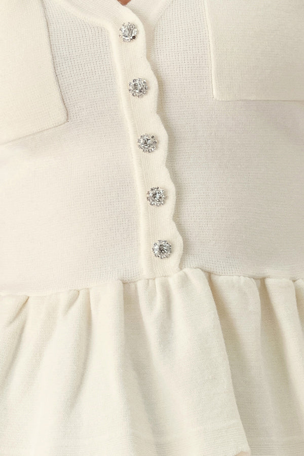 A woman wearing a short-sleeve off-white sweater knit blouse with a scalloped V-neckline, front buttons, and chest pockets | FREEMARKET