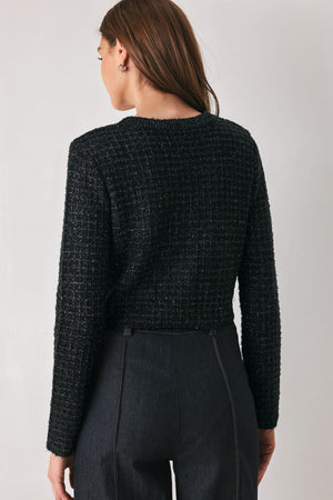 Woman wearing a black long sleeve tweed cardigan with embellished snowflake buttons | FREEMARKET 