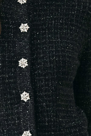 Woman wearing a black long sleeve tweed cardigan with embellished snowflake buttons | FREEMARKET 