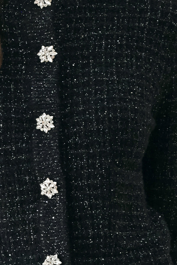 Woman wearing a black long sleeve tweed cardigan with embellished snowflake buttons | FREEMARKET 