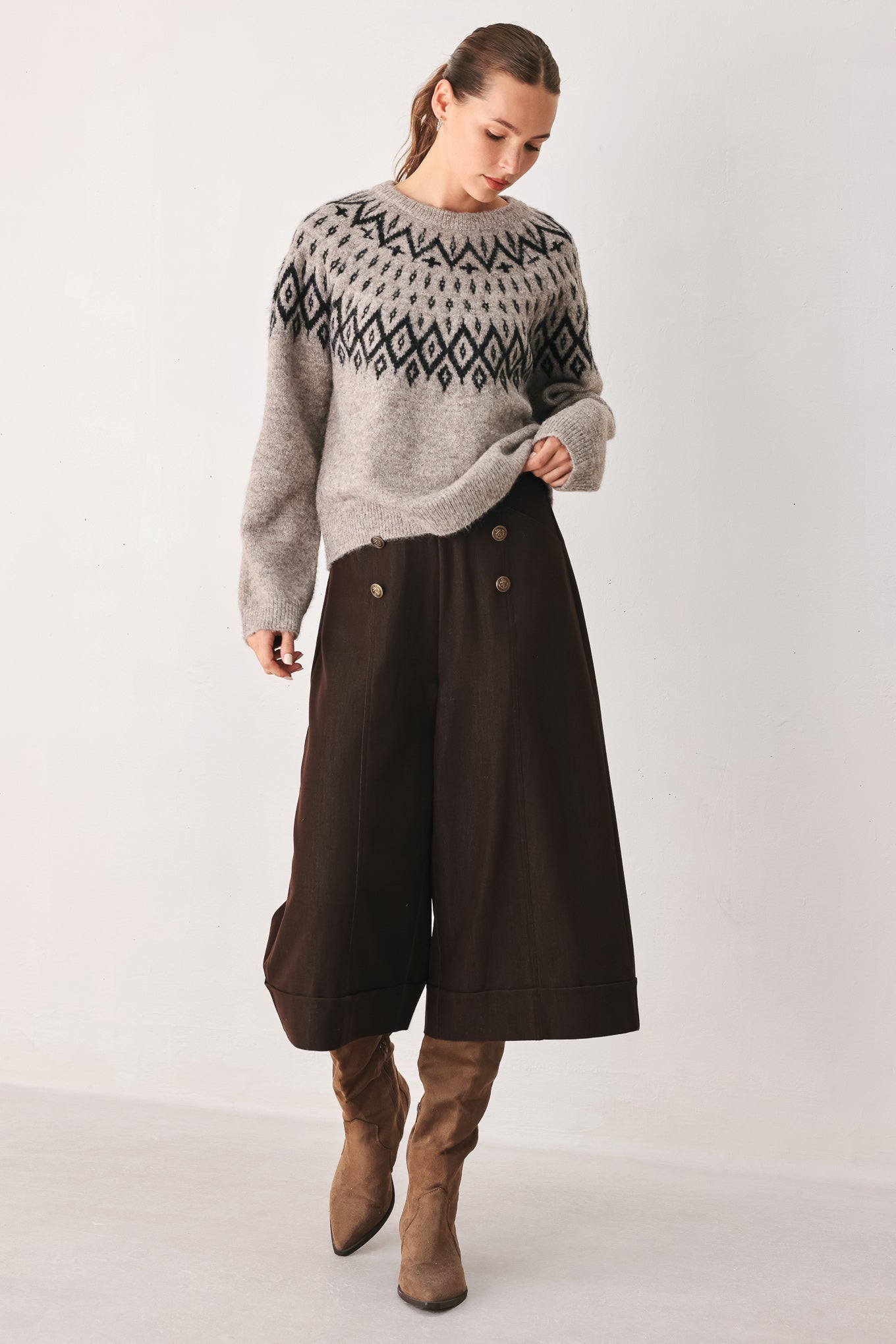 A model wearing a taupe knit sweater with a black geometric pattern across the chest | FREEMARKET