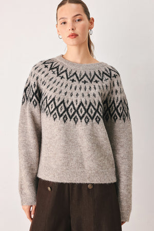 A model wearing a taupe knit sweater with a black geometric pattern across the chest | FREEMARKET